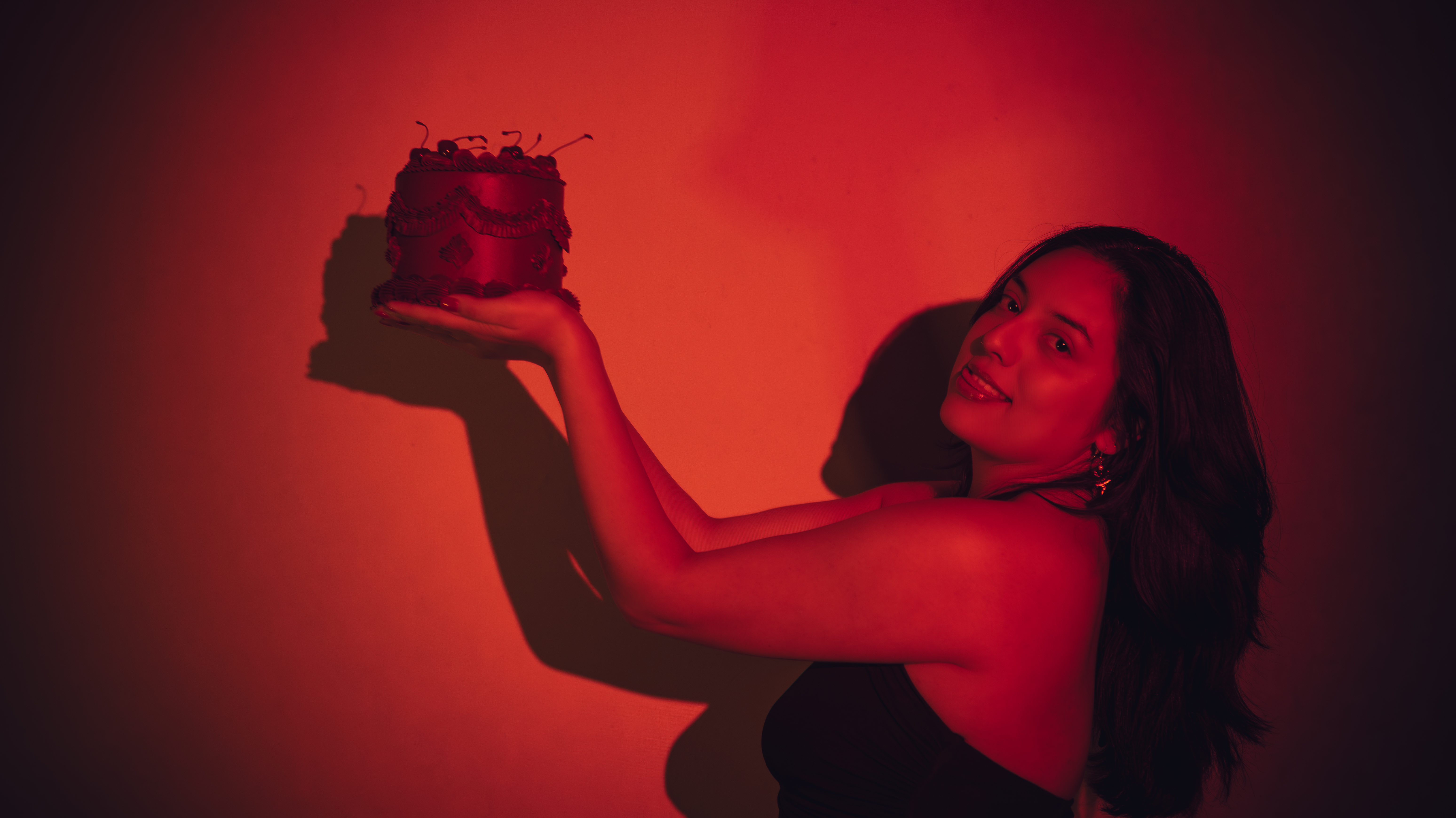 Woman in black dress holding a birthday cake