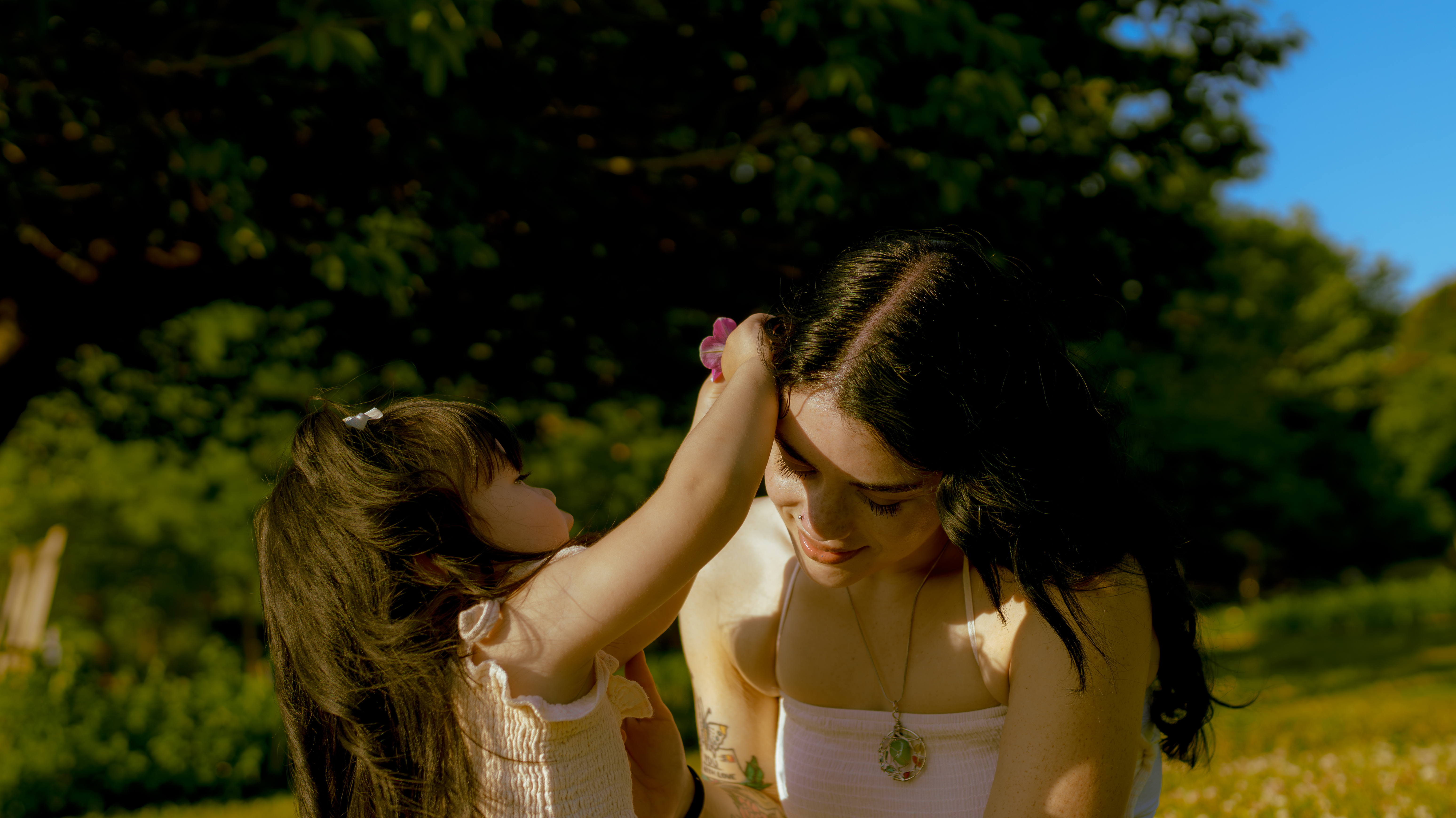 little girl putting flower in moms hair